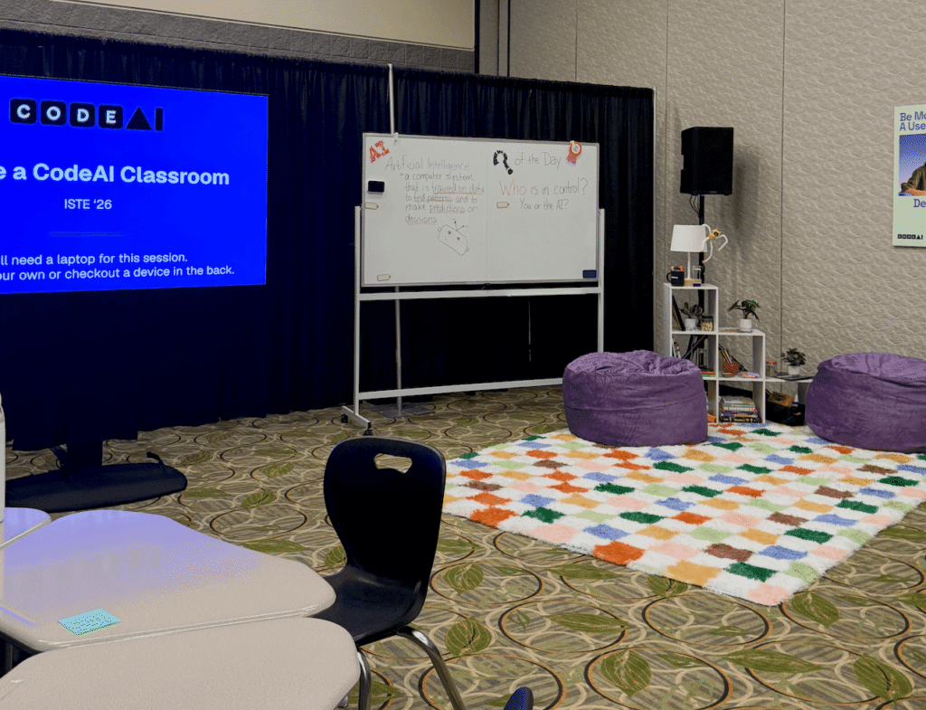 CodeAI model classroom at ISTELive 26 with flexible seating, bean bag chairs, and a whiteboard asking students Who is in control? You or the AI?